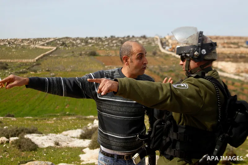A Palestinian man argues with Israeli soldiers during the demolition of a Palestinian house at the order of the Israeli army as he tries to stop the demolition in the West Bank village of Biet Ula, west of Hebron January...