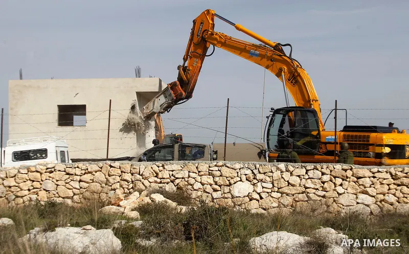 An Israeli bulldozer demolishes a Palestinian house at the order of the Israeli army in the West Bank village of Biet Ula, west of Hebron January 21, 2016. The owners of the house said they were informed by the Israeli a...