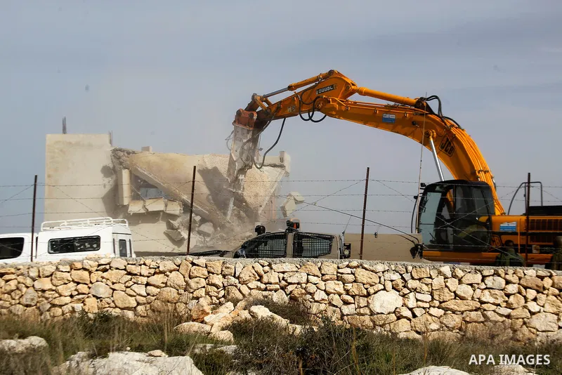 An Israeli bulldozer demolishes a Palestinian house at the order of the Israeli army in the West Bank village of Biet Ula, west of Hebron January 21, 2016. The owners of the house said they were informed by the Israeli a...