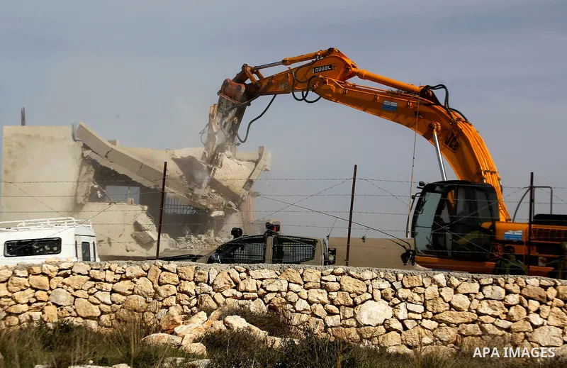 An Israeli bulldozer demolishes a Palestinian house at the order of the Israeli army in the West Bank village of Biet Ula, west of Hebron January 21, 2016. The owners of the house said they were informed by the Israeli a...