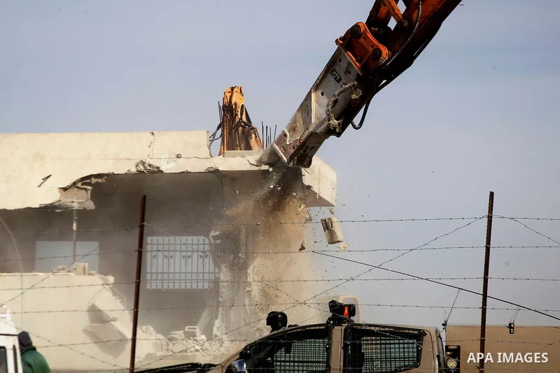 Israeli soldiers stand guard during the demolition of a Palestinian house at the order of the Israeli army in the West Bank village of Biet Ula, west of Hebron January 21, 2016. The owners of the house said they were inf...