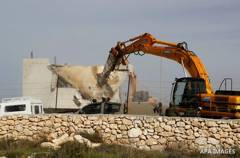 Israeli soldiers stand guard during the demolition of a Palestinian house at the order of the Israeli army in the West Bank village of Biet Ula, west of Hebron January 21, 2016. The owners of the house said they were inf...