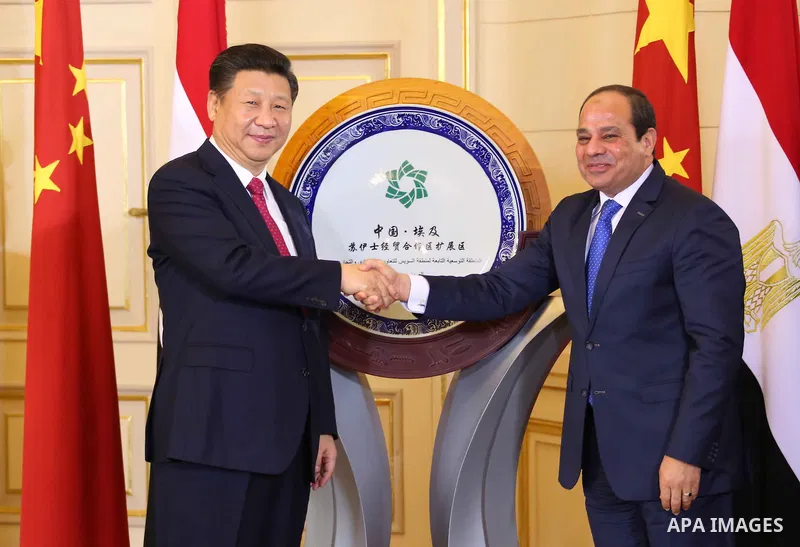 Egypt's President Abdel Fattah al-Sisi shaking hands with his Chinese countpart Xi Jinping in front of a plaque clebrating a Chinese indutrial project in the Suez Canal during a ceremony in the Egyptian capital Cairo. Ji...