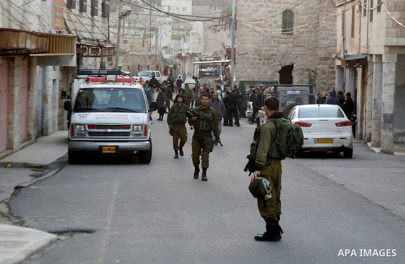 Israeli security forces stand guard during Israeli settlers under the escort of Israeli border police enter two homes in a building in the centre of the Palestinian city Hebron, sparking violent clashes amid a disputed c...
