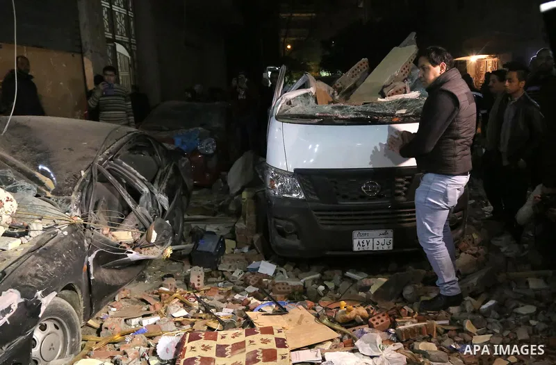 Egyptians gather at the scene of a bomb blast in a main street in Giza on January 21, 2016. A bomb attack killed six people, including three policemen, on Thursday near a road leading to the pyramids in the Cairo suburb...