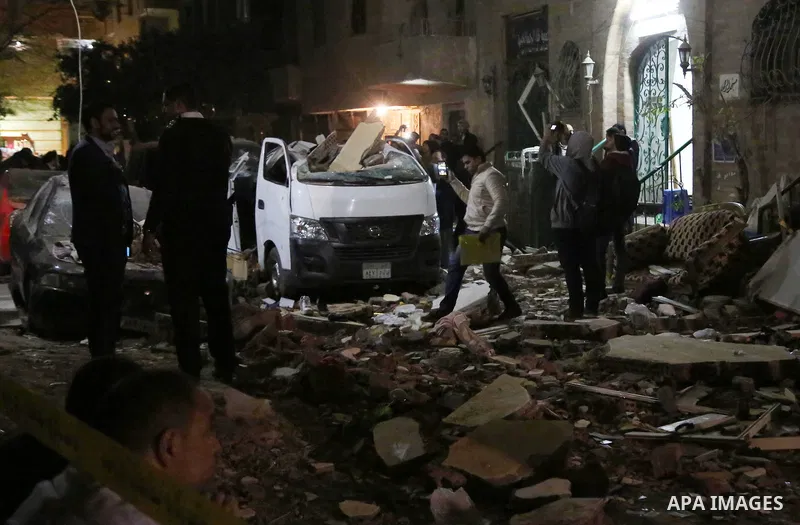 Egyptians gather at the scene of a bomb blast in a main street in Giza on January 21, 2016. A bomb attack killed six people, including three policemen, on Thursday near a road leading to the pyramids in the Cairo suburb...