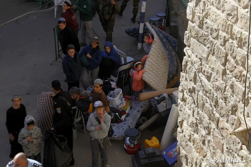 Jewish settlers collect their belongings as dozens of settlers were evacuated by Israeli security forces from two homes in the heart of the West Bank city of Hebron on January 22, 2016, the day after they entered the bui...