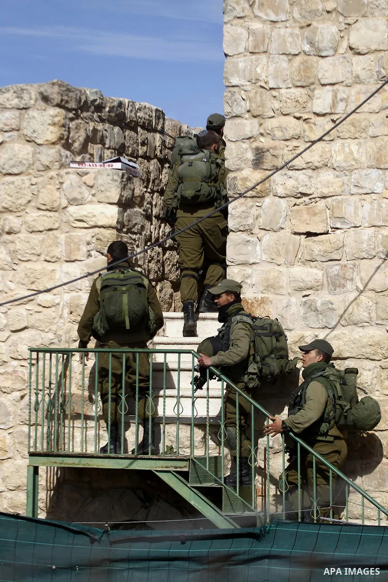 Israeli security forces stands guard as dozens of settlers were evacuated by Israeli security forces from two homes in the heart of the West Bank city of Hebron on January 22, 2016, the day after they entered the buildin...