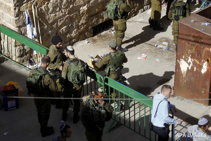 Israeli security forces stands guard as dozens of settlers were evacuated by Israeli security forces from two homes in the heart of the West Bank city of Hebron on January 22, 2016, the day after they entered the buildin...