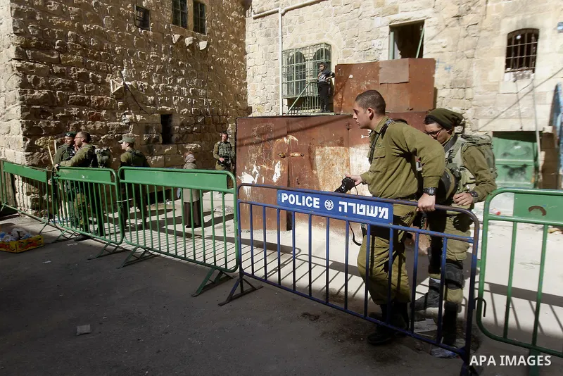 Israeli security forces stands guard as dozens of settlers were evacuated by Israeli security forces from two homes in the heart of the West Bank city of Hebron on January 22, 2016, the day after they entered the buildin...