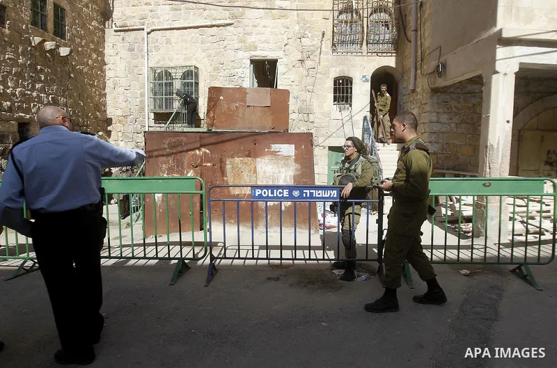 Israeli security forces stands guard as dozens of settlers were evacuated by Israeli security forces from two homes in the heart of the West Bank city of Hebron on January 22, 2016, the day after they entered the buildin...