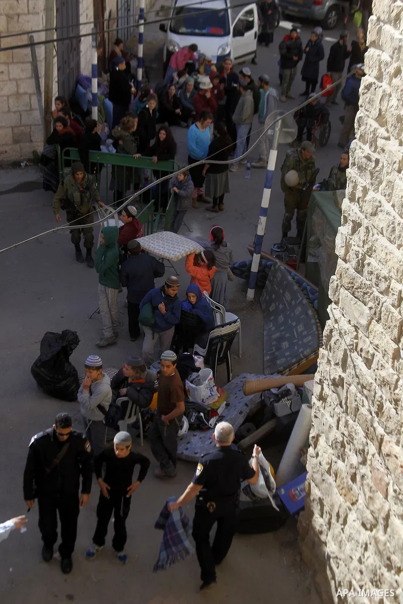 Jewish settlers collect their belongings as dozens of settlers were evacuated by Israeli security forces from two homes in the heart of the West Bank city of Hebron on January 22, 2016, the day after they entered the bui...