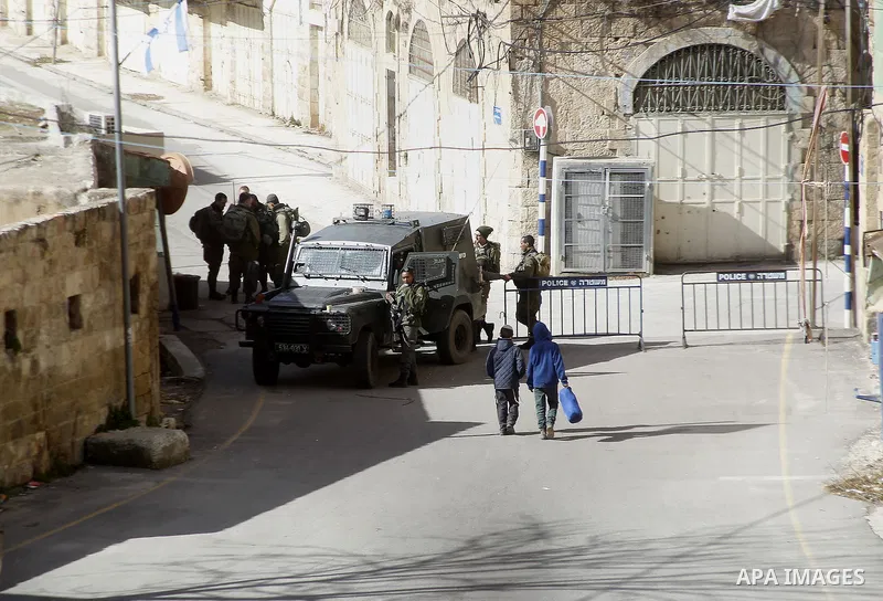 Israeli security forces stands guard as dozens of settlers were evacuated by Israeli security forces from two homes in the heart of the West Bank city of Hebron on January 22, 2016, the day after they entered the buildin...