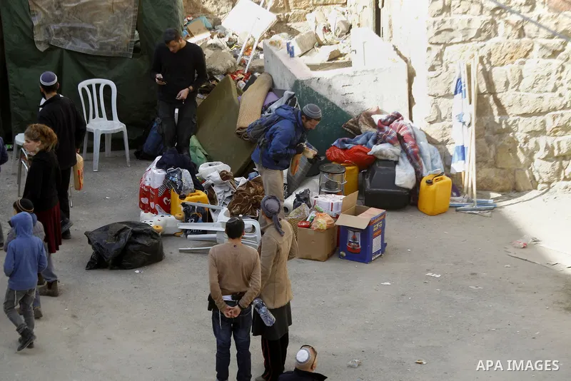 Jewish settlers collect their belongings as dozens of settlers were evacuated by Israeli security forces from two homes in the heart of the West Bank city of Hebron on January 22, 2016, the day after they entered the bui...
