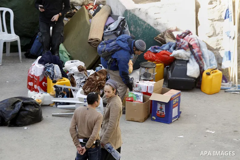 Jewish settlers collect their belongings as dozens of settlers were evacuated by Israeli security forces from two homes in the heart of the West Bank city of Hebron on January 22, 2016, the day after they entered the bui...