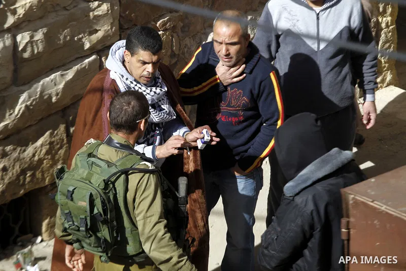 Palestinians argue with an Israeli solider as dozens of settlers were evacuated by Israeli security forces from two homes in the heart of the West Bank city of Hebron on January 22, 2016, the day after they entered the b...