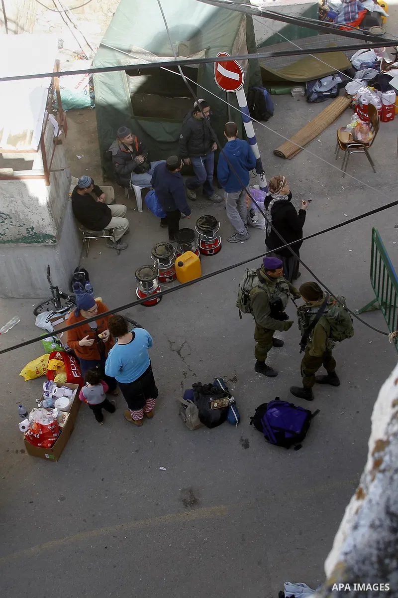Jewish settlers collect their belongings as dozens of settlers were evacuated by Israeli security forces from two homes in the heart of the West Bank city of Hebron on January 22, 2016, the day after they entered the bui...