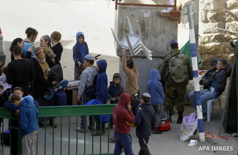 Jewish settlers collect their belongings as dozens of settlers were evacuated by Israeli security forces from two homes in the heart of the West Bank city of Hebron on January 22, 2016, the day after they entered the bui...