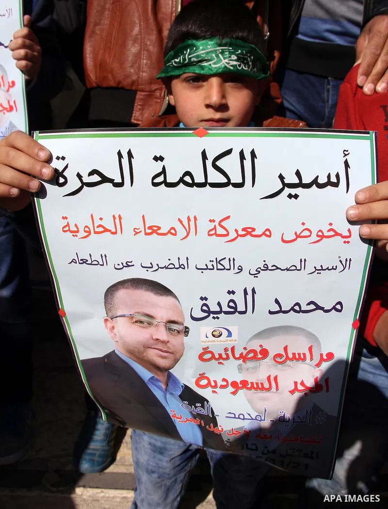 Palestinians take part in a demonstration demanding the release of Palestinian journalist Mohammed al-Qiq (portrait) from Israeli jails, in front of Jerusalem's Dome of the Rock mosque at the Al-Aqsa mosque compound on J...