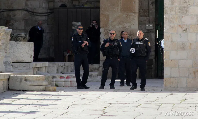 Israeli security forces stand guard during a demonstration demanding the release of Palestinian journalist Mohammed al-Qiq (portrait) from Israeli jails, in front of Jerusalem's Dome of the Rock mosque at the Al-Aqsa mos...
