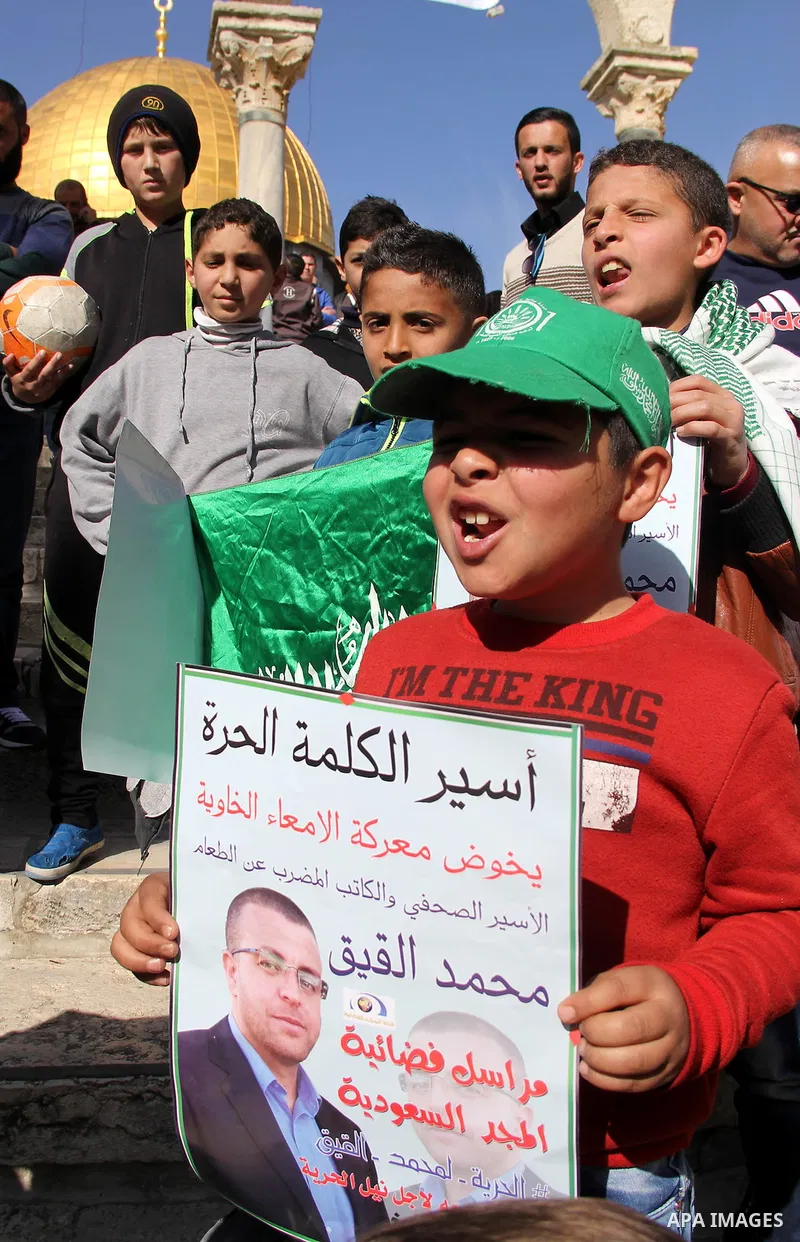Palestinians take part in a demonstration demanding the release of Palestinian journalist Mohammed al-Qiq (portrait) from Israeli jails, in front of Jerusalem's Dome of the Rock mosque at the Al-Aqsa mosque compound on J...