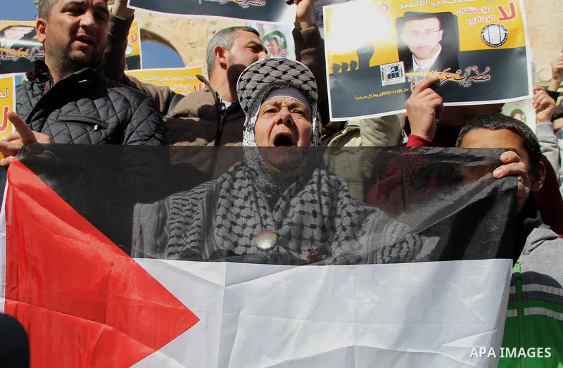 Palestinians carry placards bearing the portraits of 10 reported Palestinian attackers, whose bodies are still under Israeli custody, during a demonstration demanding the release of the bodies and the release of Palestin...