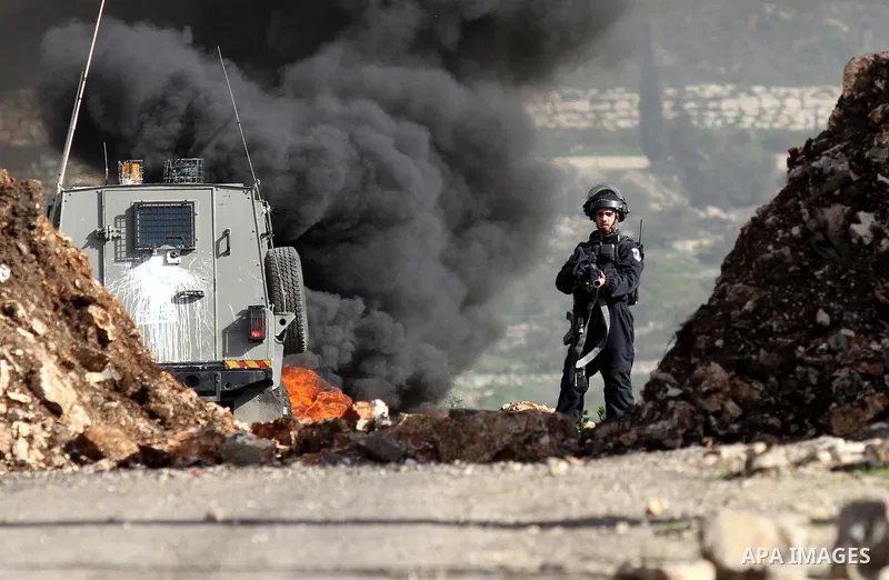 Israeli security forces take position during clashes with Palestinian portesters following a protest against the expropriation of Palestinian land by Israel in the West Bank village of Kafr Qaddum, near the northern city...