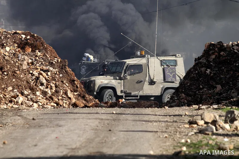 Israeli security forces take position during clashes with Palestinian portesters following a protest against the expropriation of Palestinian land by Israel in the West Bank village of Kafr Qaddum, near the northern city...