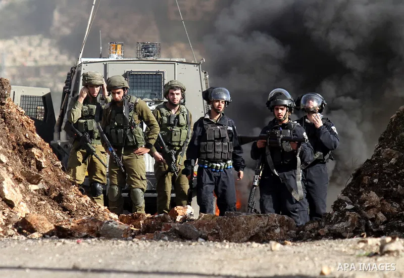 Israeli security forces take position during clashes with Palestinian portesters following a protest against the expropriation of Palestinian land by Israel in the West Bank village of Kafr Qaddum, near the northern city...