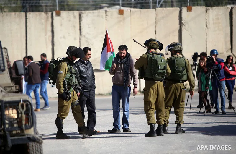 Palestinians argue with Israeli security forces during a demonstration demanding the release of Palestinian journalist Mohammed al-Qiq from Israeli jails, in Beit El on the outskirts of the West Bank city of Ramallah on...