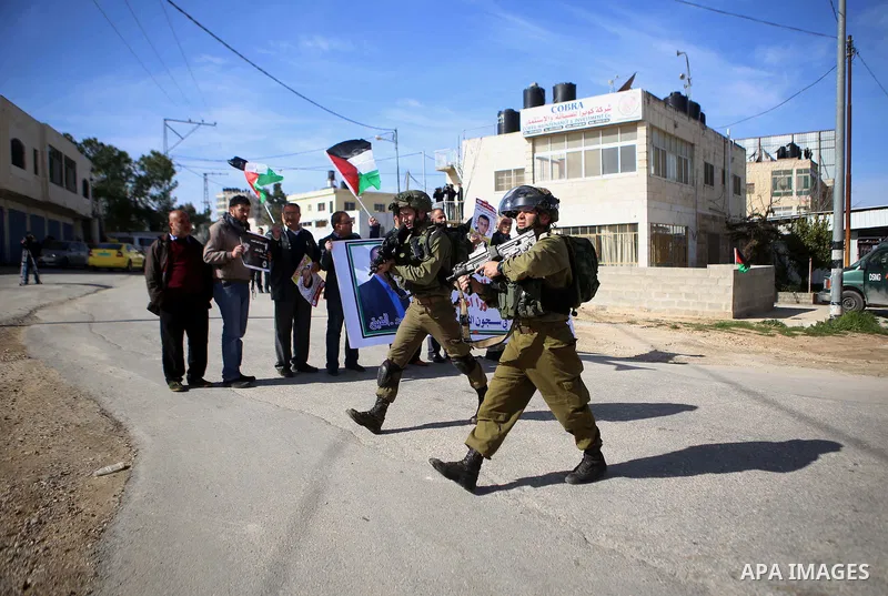 Israeli security forces stand guard during a demonstration demanding the release of Palestinian journalist Mohammed al-Qiq from Israeli jails, in Beit El on the outskirts of the West Bank city of Ramallah on January 22,...
