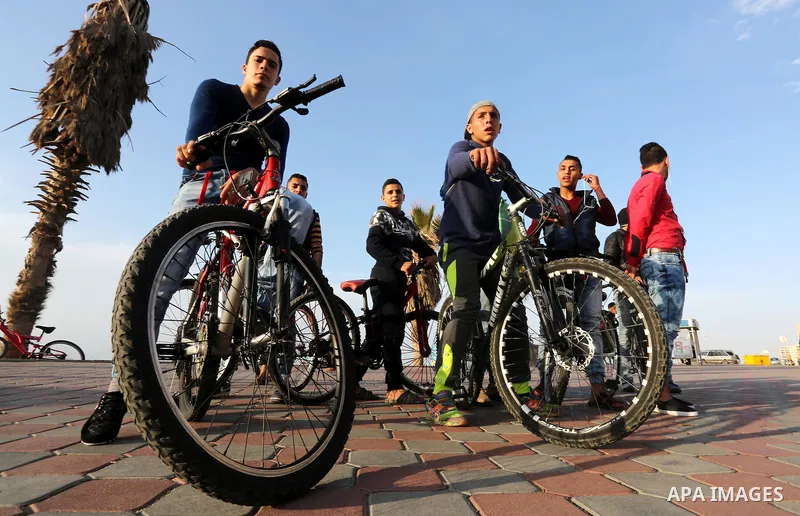 Palestinian youths perform stunts with bicycles on the beach of the Mediterranean Sea in Gaza City on Jan. 22, 2016. Photo by Mohammed Asad