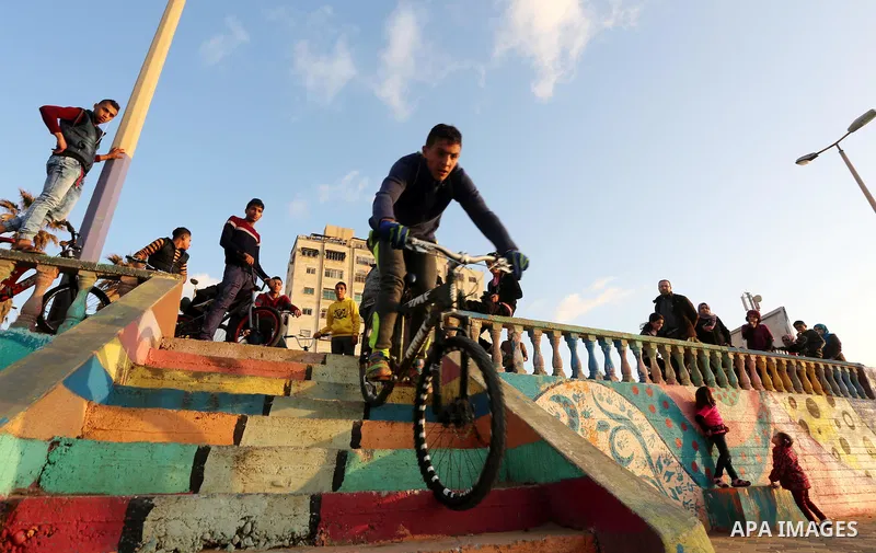 A Palestinian youth performs stunts with bicycles on the beach of the Mediterranean Sea in Gaza City on Jan. 22, 2016. Photo by Mohammed Asad
