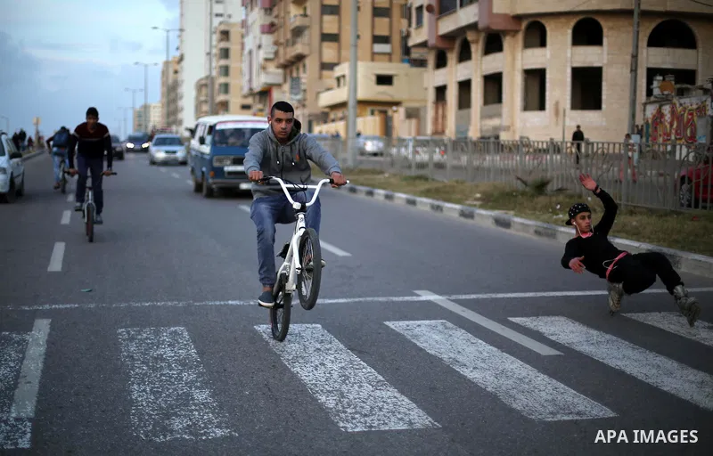 A Palestinian youth performs stunts with bicycles on the beach of the Mediterranean Sea in Gaza City on Jan. 22, 2016. Photo by Mohammed Asad