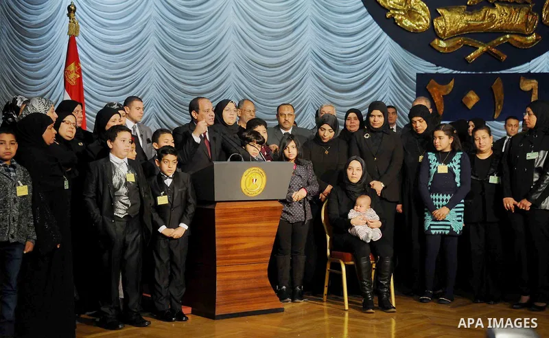 Egyptian President Abdel-Fattah el-Sissi poses for a photo with families of policemen killed in militant attacks, at a ceremony marking Police Day, which falls on Jan. 25, the anniversary of the 2011 uprising that topple...