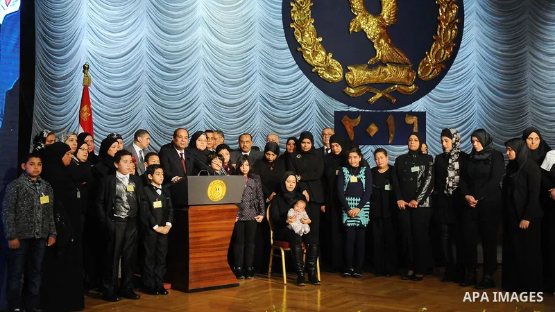 Egyptian President Abdel-Fattah el-Sissi poses for a photo with families of policemen killed in militant attacks, at a ceremony marking Police Day, which falls on Jan. 25, the anniversary of the 2011 uprising that topple...