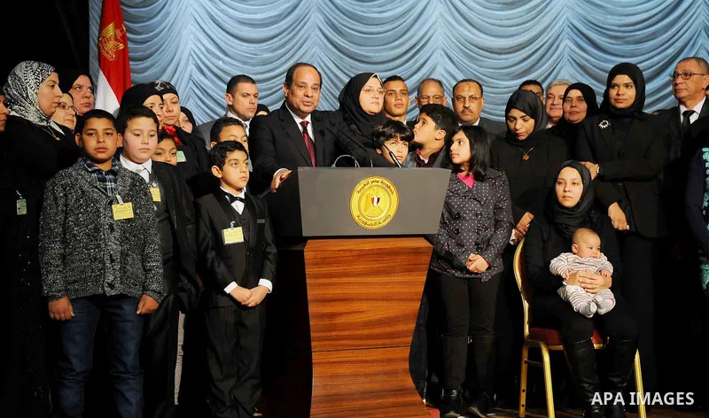 Egyptian President Abdel-Fattah el-Sissi poses for a photo with families of policemen killed in militant attacks, at a ceremony marking Police Day, which falls on Jan. 25, the anniversary of the 2011 uprising that topple...