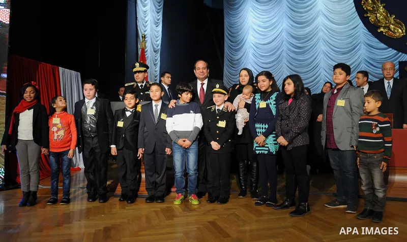 Egyptian President Abdel-Fattah el-Sissi poses for a photo with families of policemen killed in militant attacks, at a ceremony marking Police Day, which falls on Jan. 25, the anniversary of the 2011 uprising that topple...