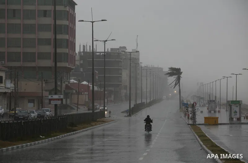 A Palestinian man rids a motorcycle in a street flooded by rain water in Gaza City, January 24, 2016. Photo by Mohammed Asad