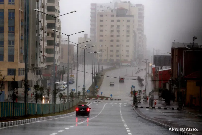 A Palestinian man drives his car in a street flooded by rain water in Gaza City, January 24, 2016. Photo by Mohammed Asad