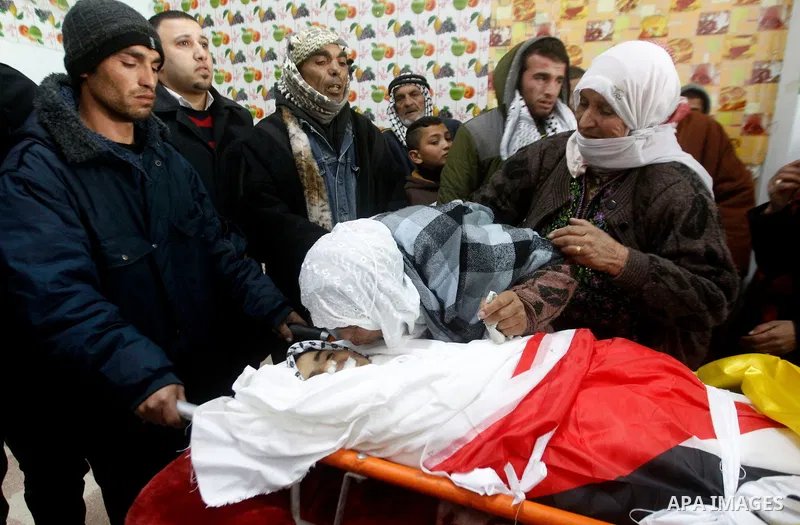 Palestinians mourn around the body of Ruqya Abu Eid, 13, during her funeral, who Israeli military said was shot dead by Israeli soldiers after he tried to stab a soldier, in the West Bank city of Hebron, on January, 24,...