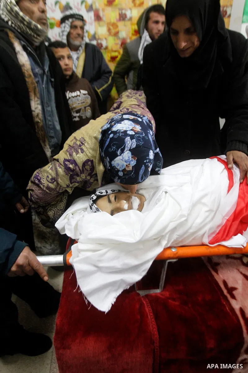 Palestinians mourn around the body of Ruqya Abu Eid, 13, during her funeral, who Israeli military said was shot dead by Israeli soldiers after he tried to stab a soldier, in the West Bank city of Hebron, on January, 24,...