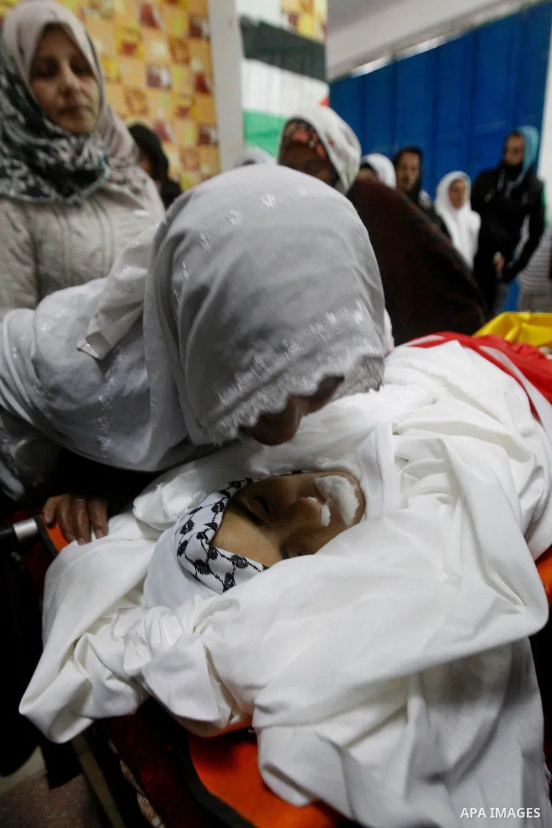 Palestinians mourn around the body of Ruqya Abu Eid, 13, during her funeral, who Israeli military said was shot dead by Israeli soldiers after he tried to stab a soldier, in the West Bank city of Hebron, on January, 24,...