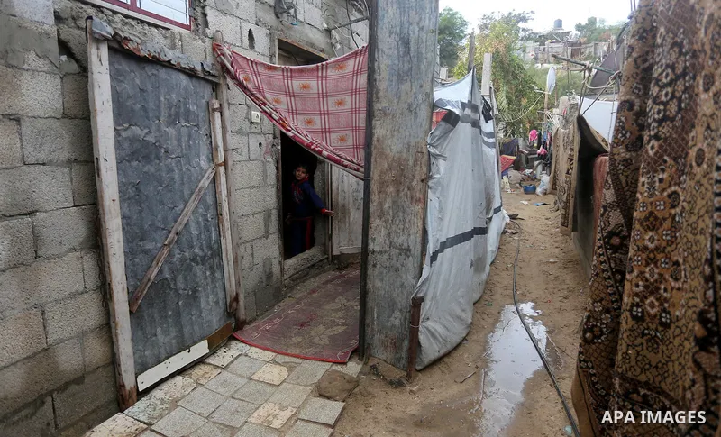 A Palestinian boy looks out his family house on a rainy day, in Khan Younis in the southern Gaza Strip, January 24, 2016. Photo by Yasser Qudih