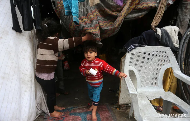 A Palestinian boy looks out his family house on a rainy day, in Khan Younis in the southern Gaza Strip, January 24, 2016. Photo by Yasser Qudih