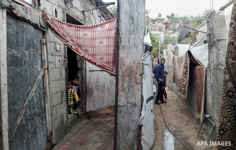 A Palestinian boy looks out his family house on a rainy day, in Khan Younis in the southern Gaza Strip, January 24, 2016. Photo by Abed Rahim Khatib