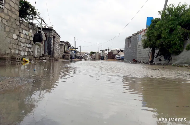 Palestinians cross a road flooded with rainwater following heavy rains, in Khan Younis in the southern Gaza Strip January 24, 2016. Photo by Abed Rahim Khatib