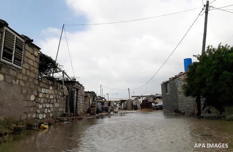 Palestinians cross a road flooded with rainwater following heavy rains, in Khan Younis in the southern Gaza Strip January 24, 2016. Photo by Abed Rahim Khatib