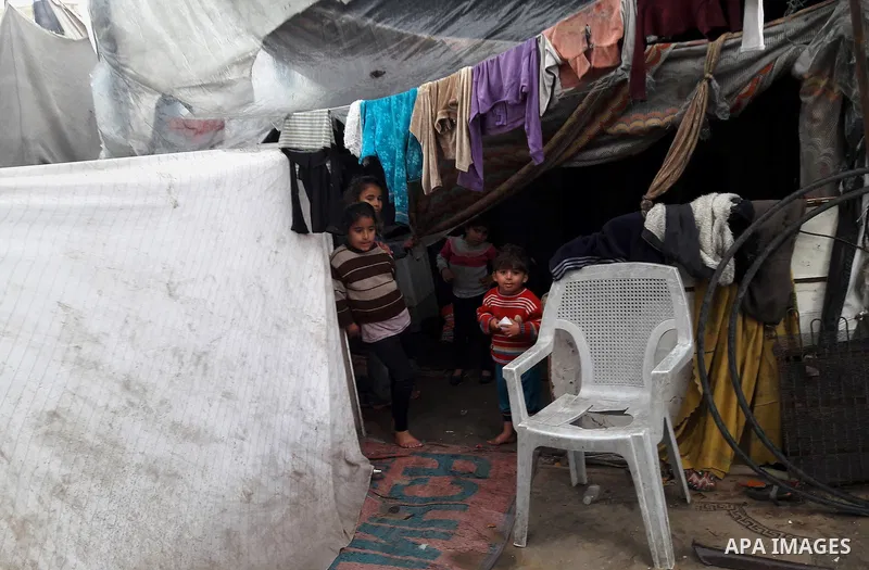 A Palestinian boy looks out his family house on a rainy day, in Khan Younis in the southern Gaza Strip, January 24, 2016. Photo by Abed Rahim Khatib