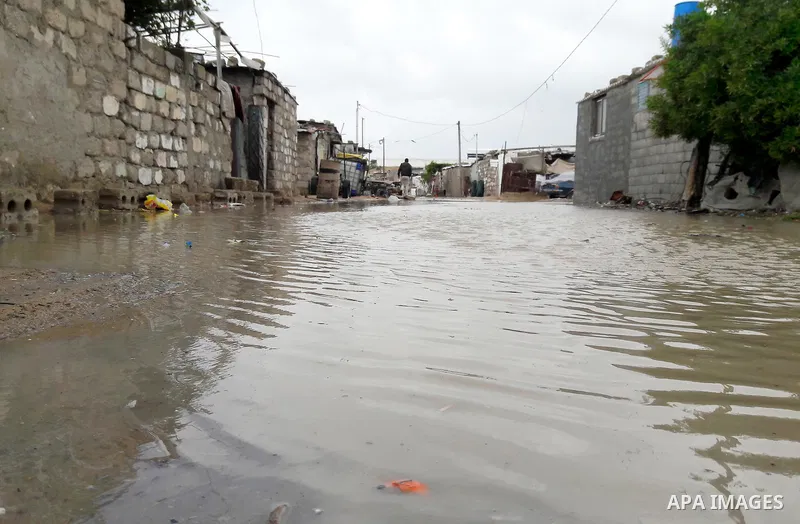 Palestinians cross a road flooded with rainwater following heavy rains, in Khan Younis in the southern Gaza Strip January 24, 2016. Photo by Abed Rahim Khatib